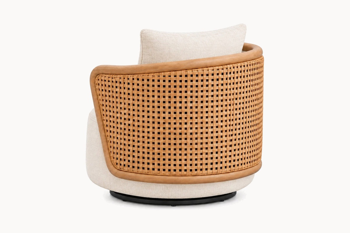 A modern barrel-style armchair with a curved tan leather frame, a woven cane backrest, and off-white fabric upholstery, shown from the rear on a white background.