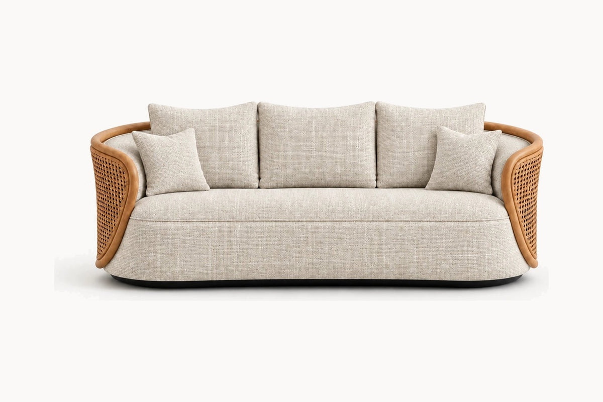 A modern curved three-seater sofa with a light beige textured fabric upholstery, natural woven rattan armrests, and four matching throw pillows, shown against a plain white background.