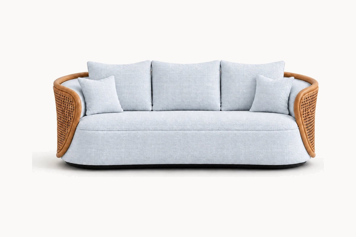 A modern curved outdoor sofa with a light blue-gray textured fabric body and natural brown woven rattan armrests, shown against a plain white background.