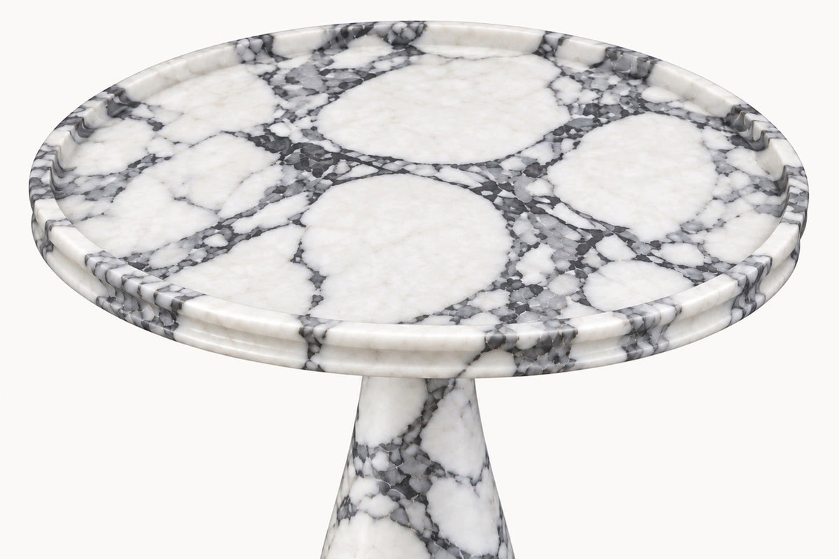 A round pedestal side table made of white marble with prominent black and gray veining, shown against a plain white background.